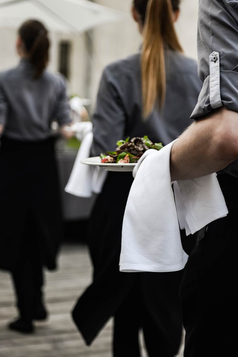 Servicepersonal trägt Essen auf